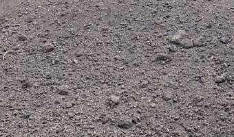 A close up of 2 way black top soil.